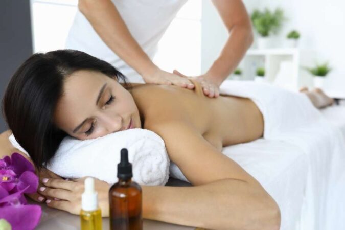 Une femme détendue reçoit un massage du dos pour évacuer le stress dans un spa.
